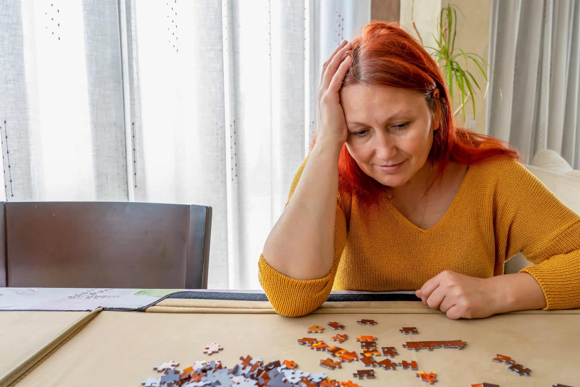 Vrouw zit voor een onafgemaakte legpuzzel