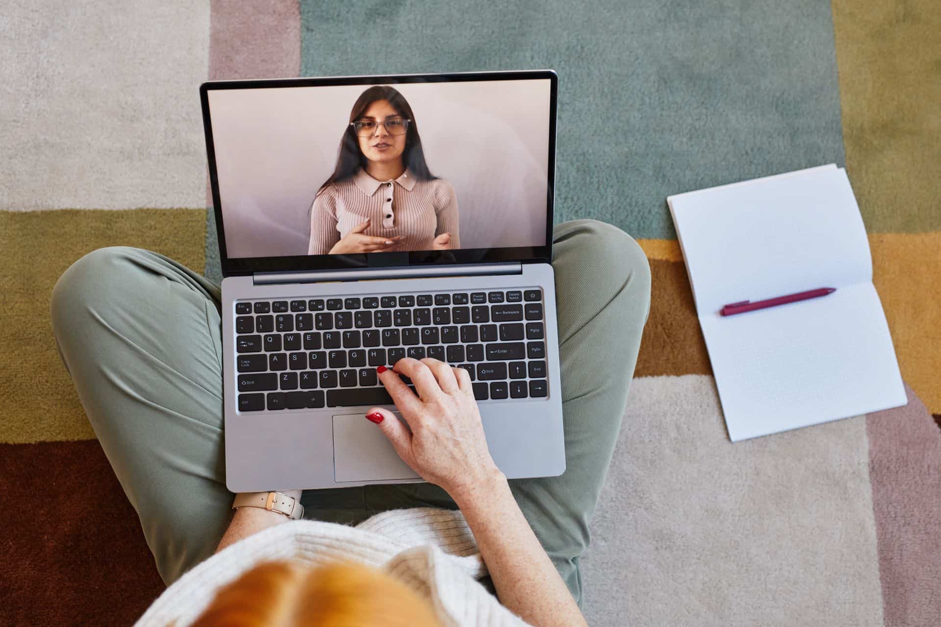 Vrouw volgt een online webinar op haar laptop