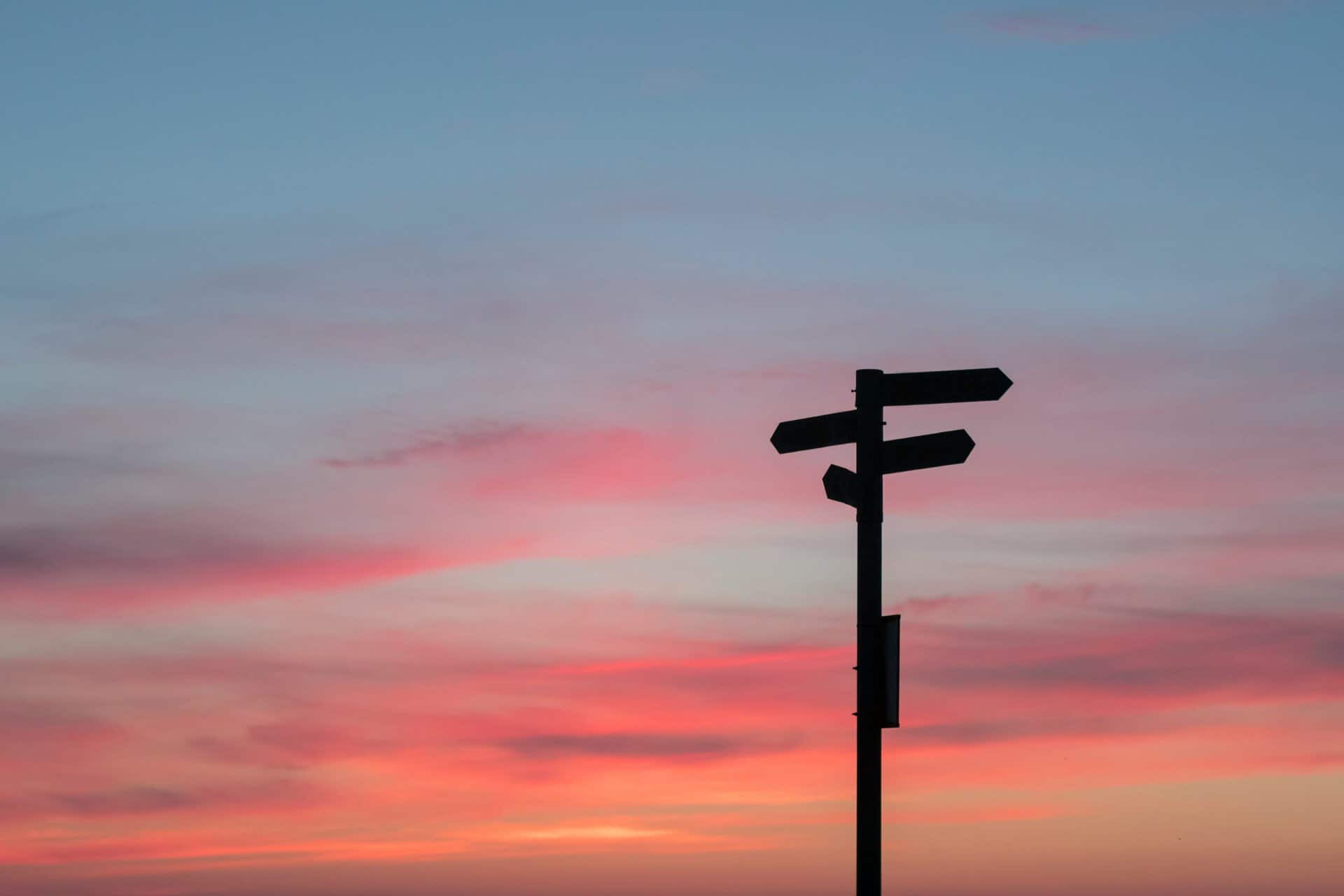 Wegwijzer bij zonsondergang